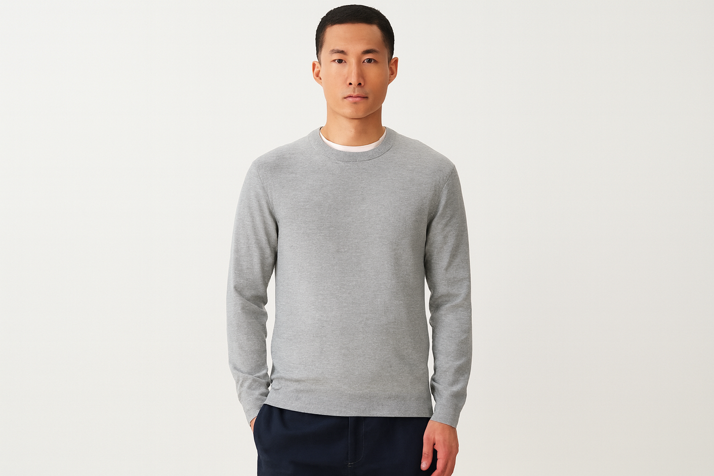 Asian model in grey crewneck sweater with arms at sides