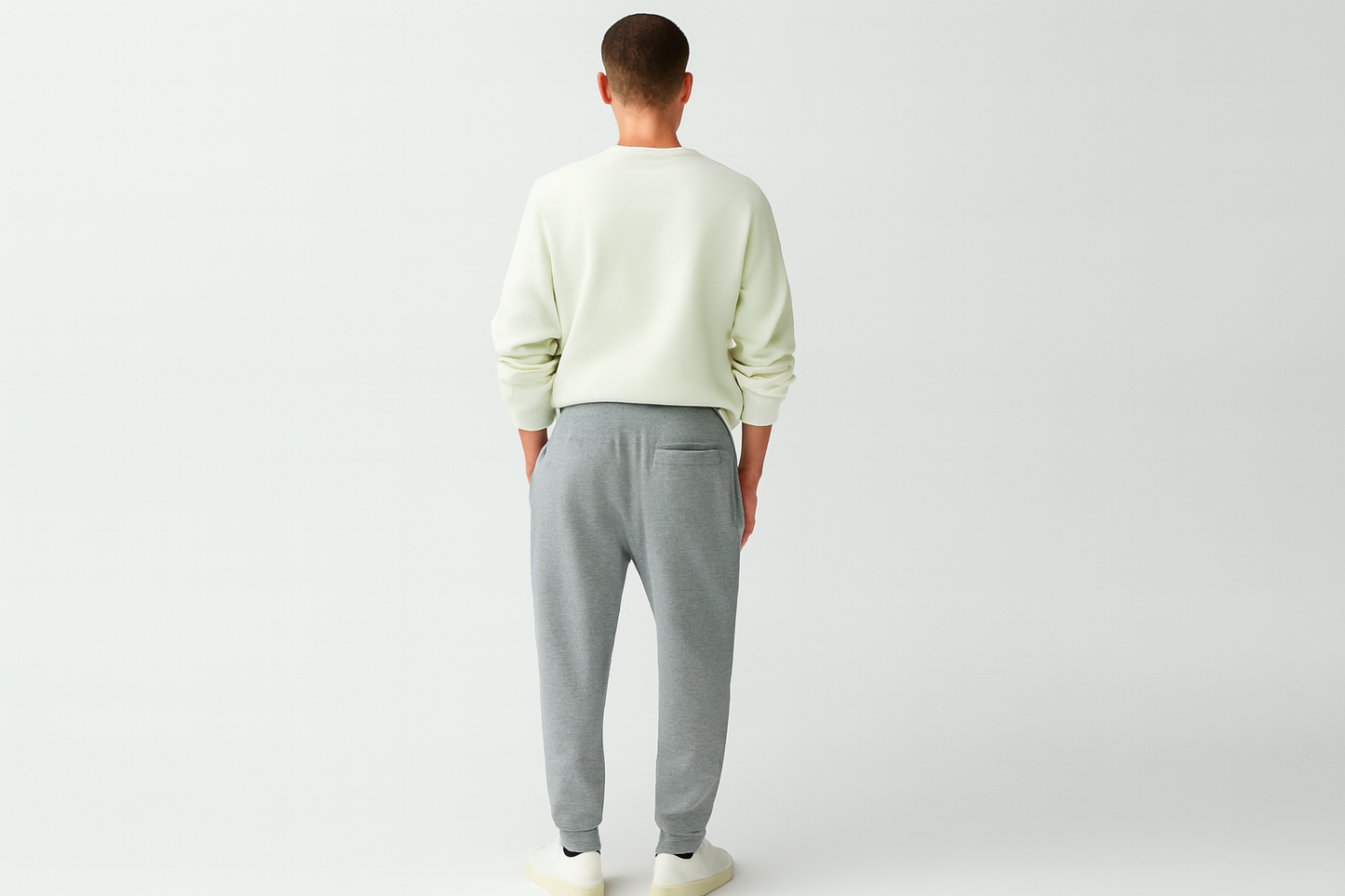 Caucasian model back view in melange grey joggers and white shirt