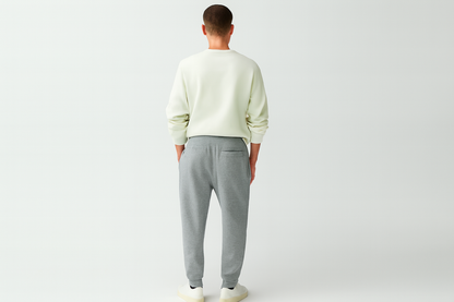 Caucasian model back view in melange grey joggers and white shirt